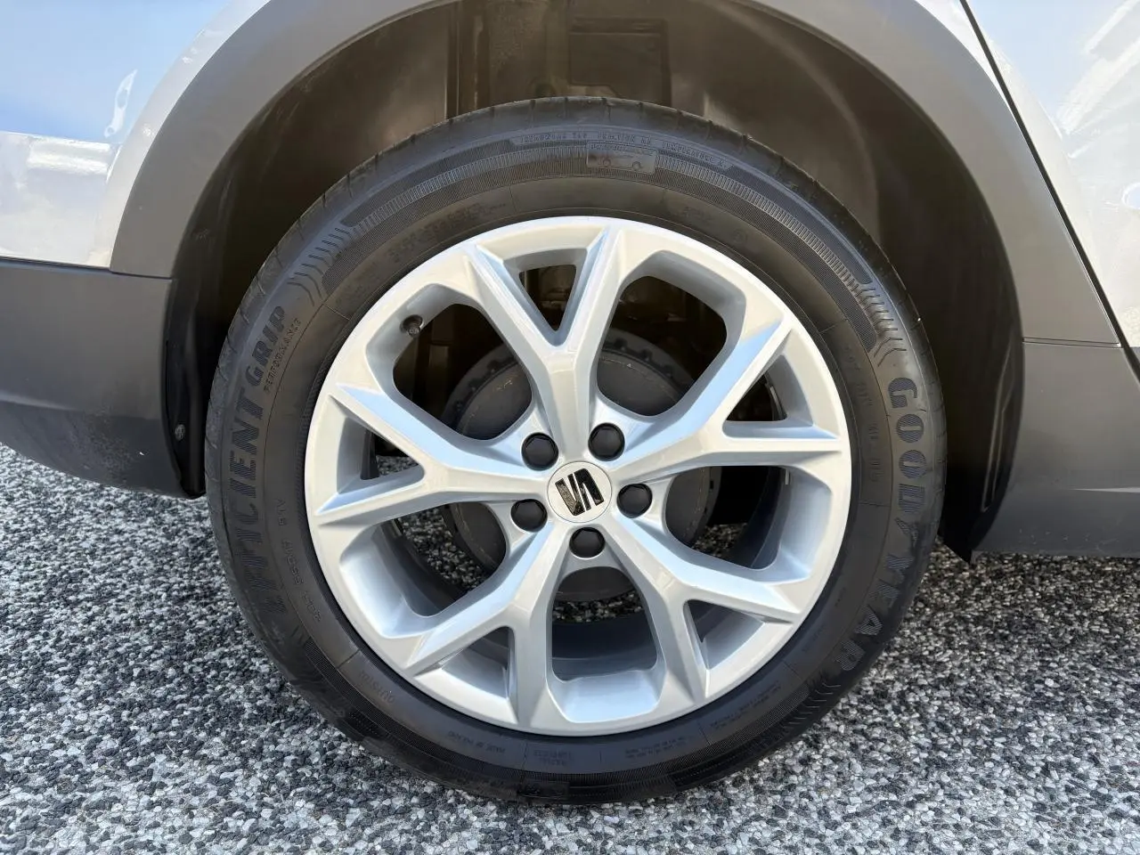 Gros plan sur la jante alliage 16 pouces argentée avec logo SEAT sur roue avant droite du SEAT Arona rouge GRS.