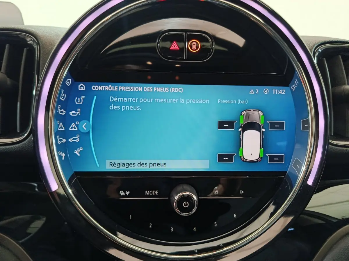 Écran tactile circulaire du tableau de bord MINI Countryman blanc, affichant le contrôle de pression des pneus.