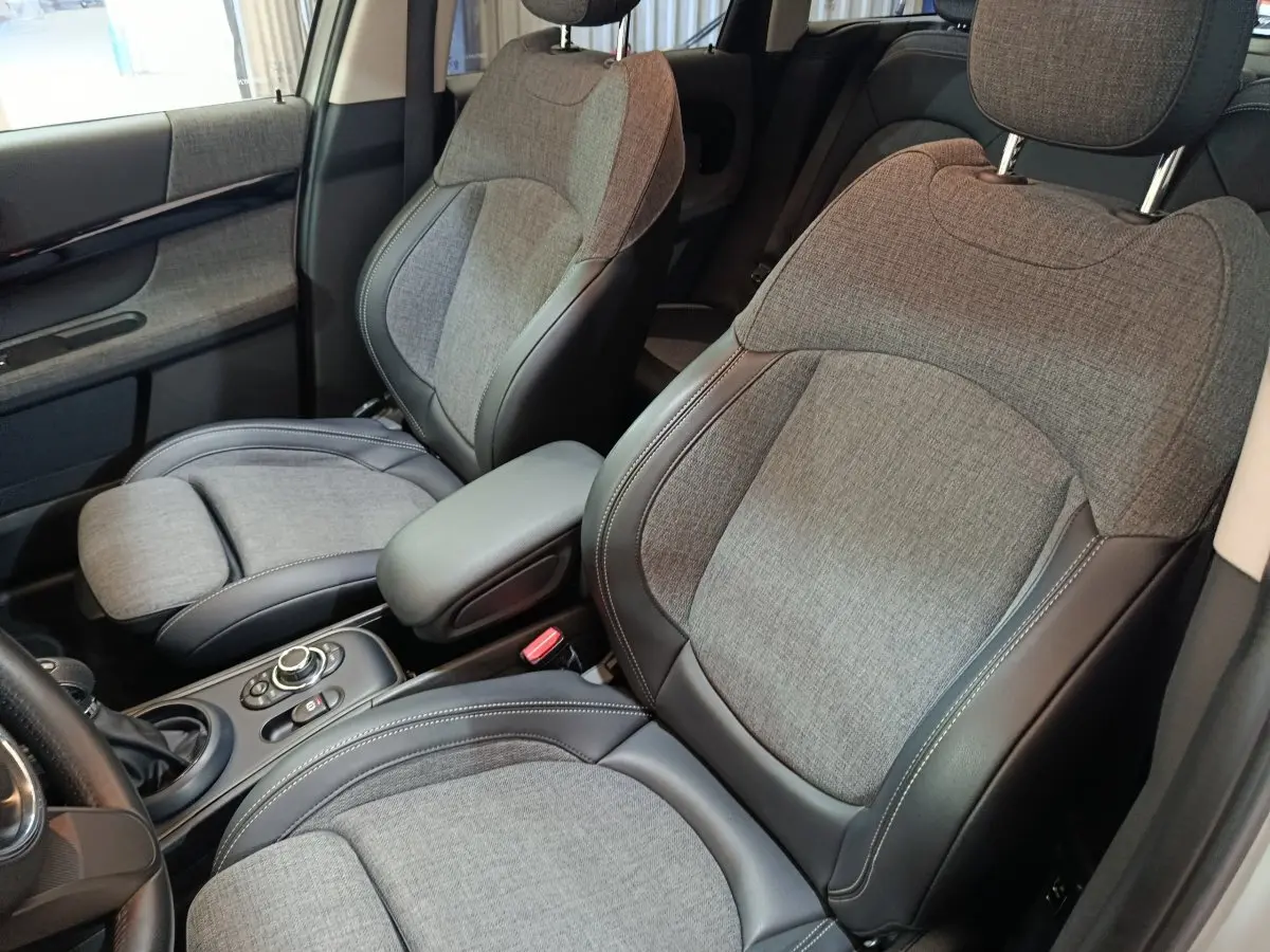 Vue intérieure rapprochée des sièges avant gris tissu et cuir du MINI Countryman Cooper SE 2021, côté gauche.