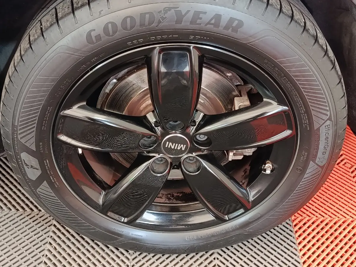 Gros plan sur la jante noire brillante à cinq branches du MINI Countryman hybride rechargeable, avec pneu Goodyear visible.