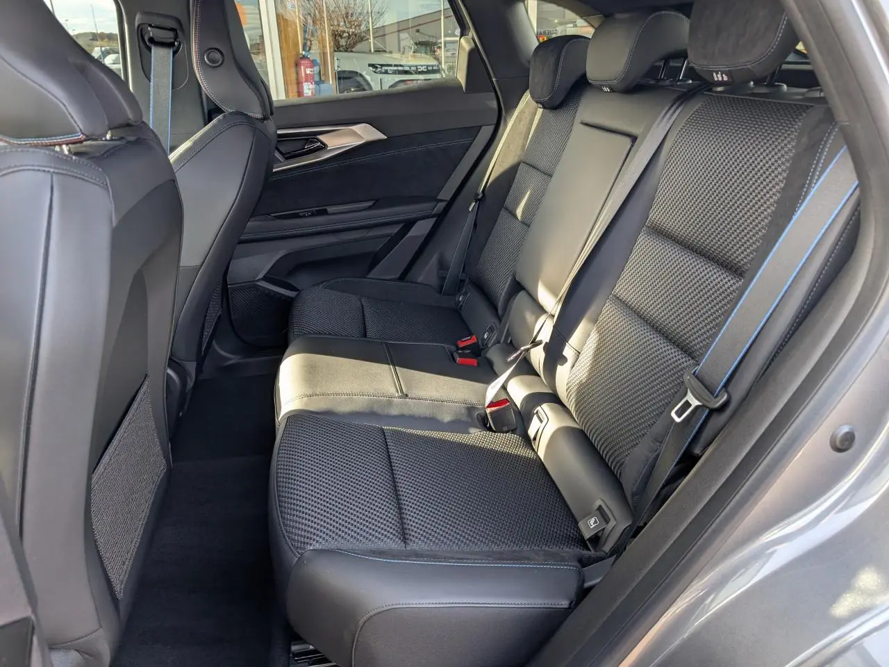 Vue latérale droite de la banquette arrière noire avec surpiqûres bleues du Renault Austral 2025 finition Esprit Alpine.