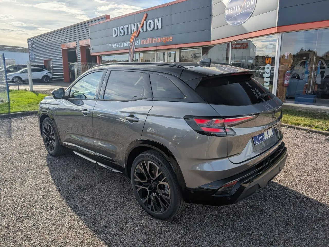 Renault Austral gris métallisé en 3/4 arrière droit, toit noir étoilé et jantes alliage noires diamantées.