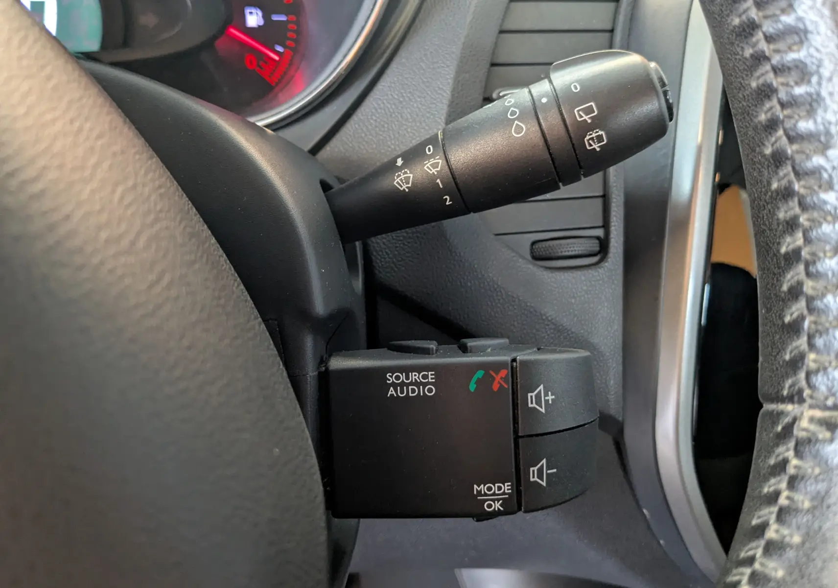 Gros plan sur les commandes au volant du Renault Captur gris clair 2017, avec boutons audio et essuie-glace visibles.