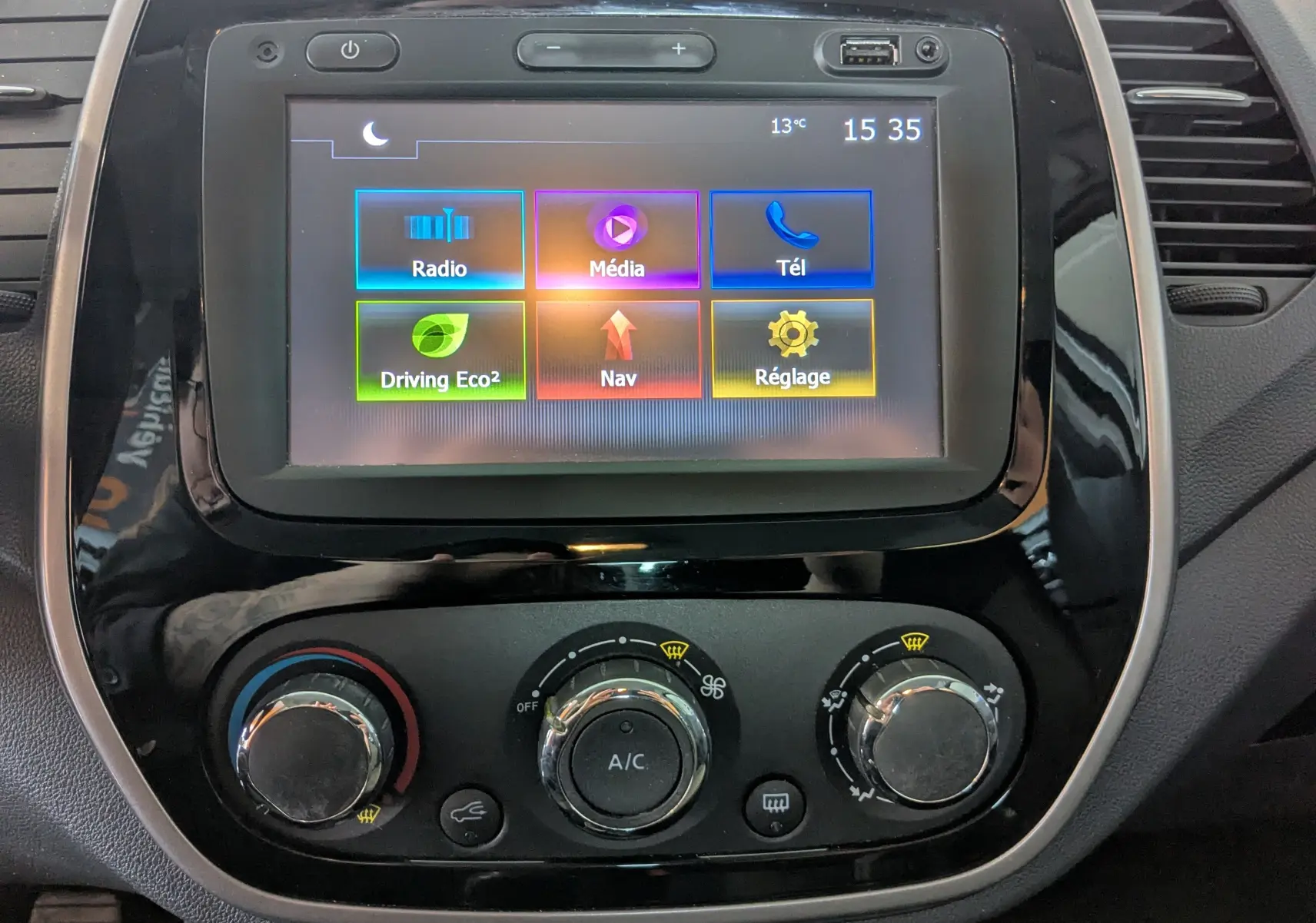 Vue rapprochée de l’écran tactile et des commandes de climatisation du Renault Captur gris clair, version 1.5 dCi 90 business.