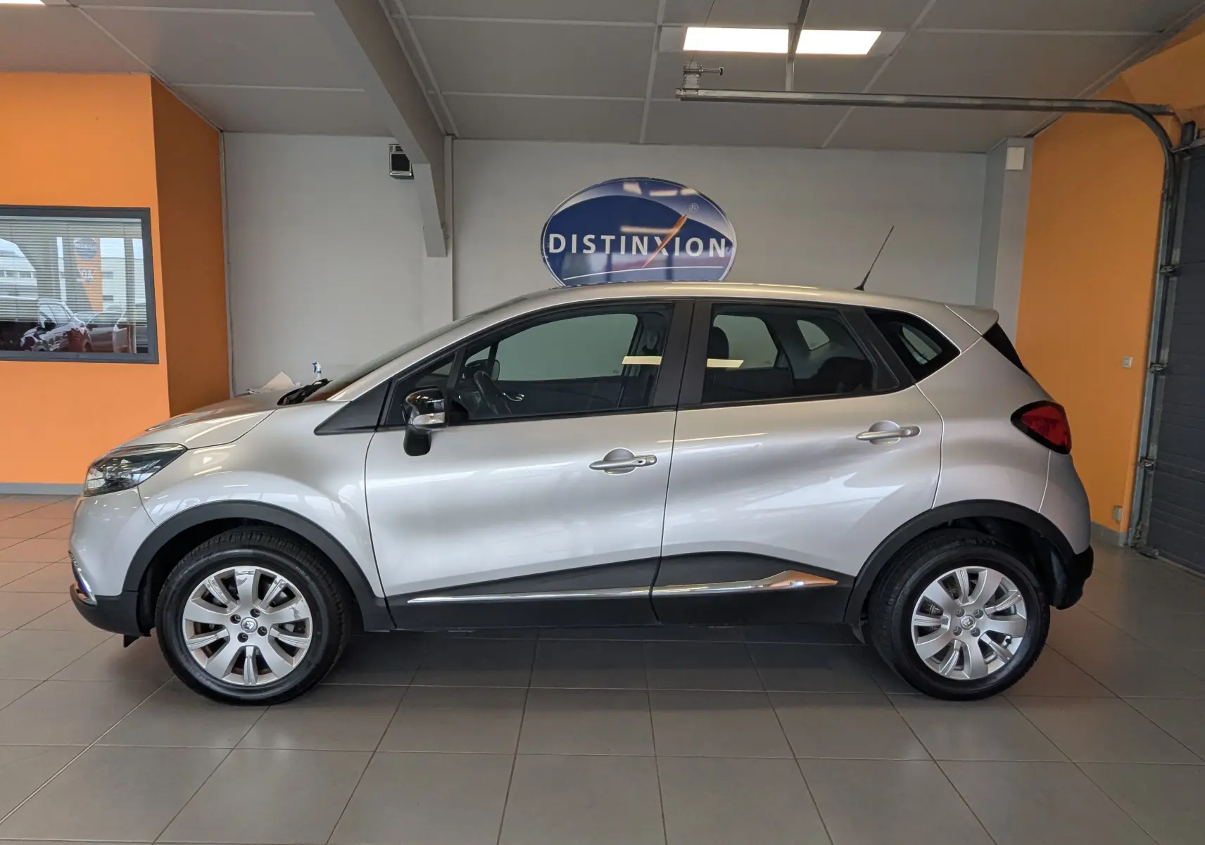 Profil droit d’un Renault Captur gris clair 2017 en intérieur, avec jantes alliage et détails noirs sur les bas de caisse.