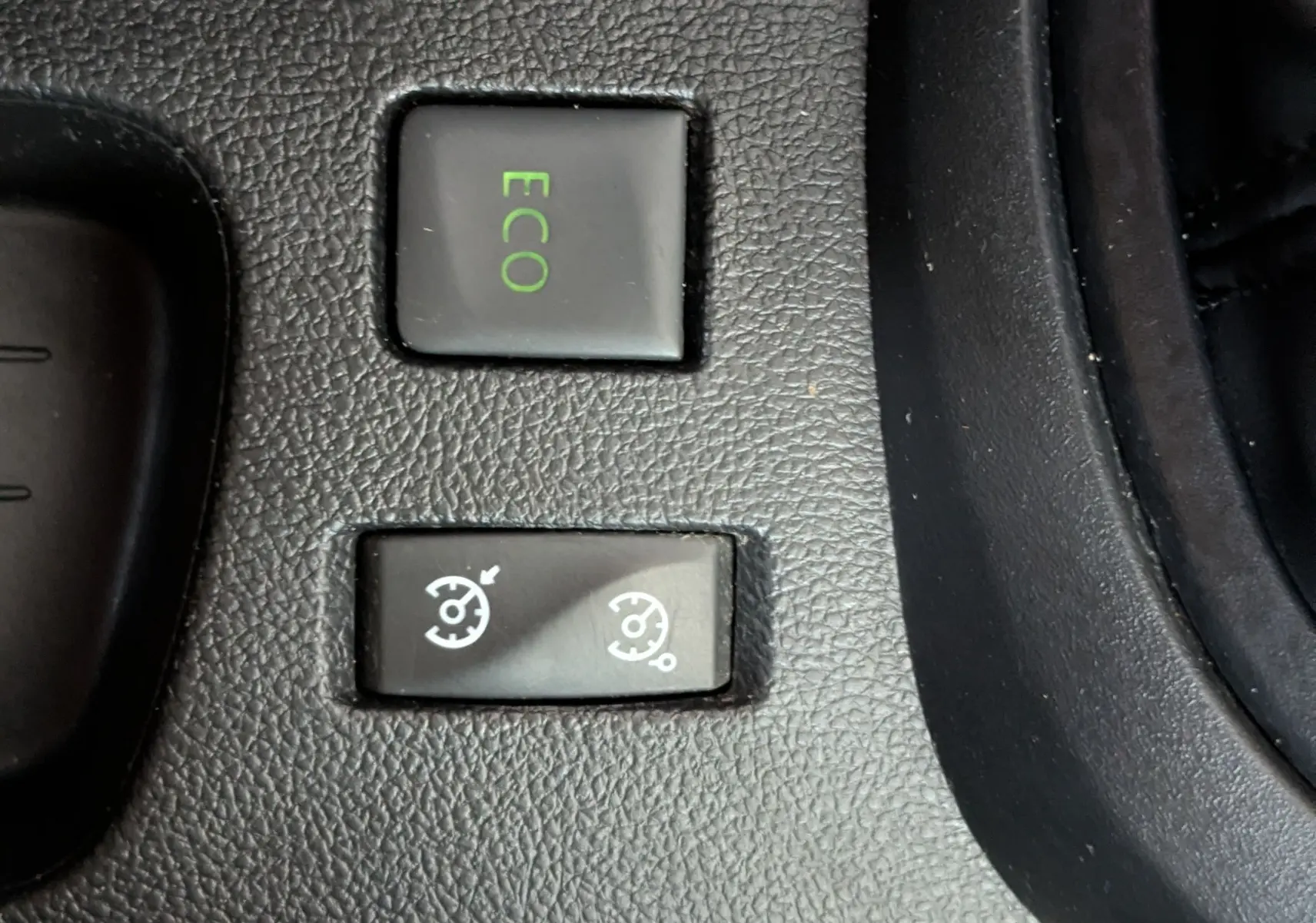 Gros plan sur les boutons de commande ECO et régulateur de vitesse sur la console centrale d’un Renault Captur gris clair 2017.