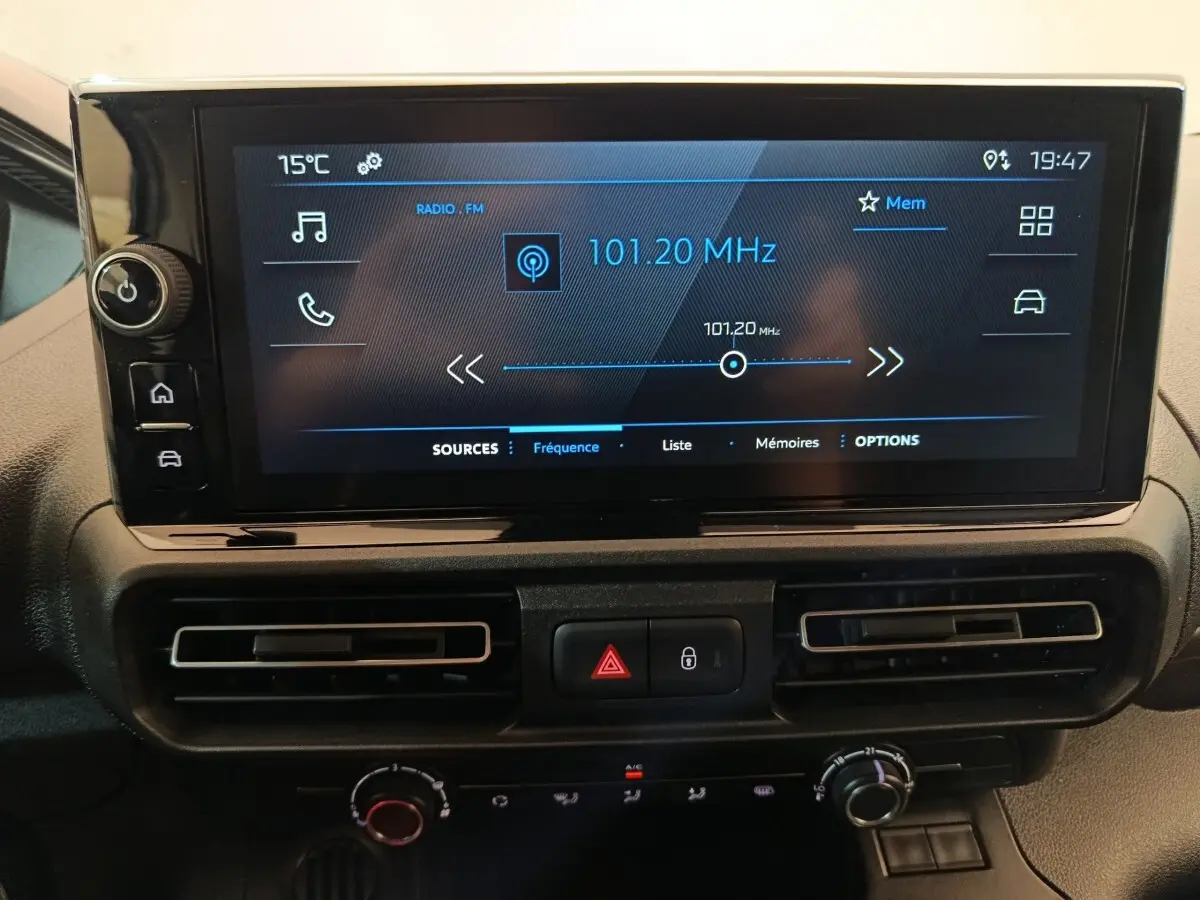 Écran tactile central du tableau de bord du Peugeot Partner blanc 2025 affichant la radio FM à 101,20 MHz.