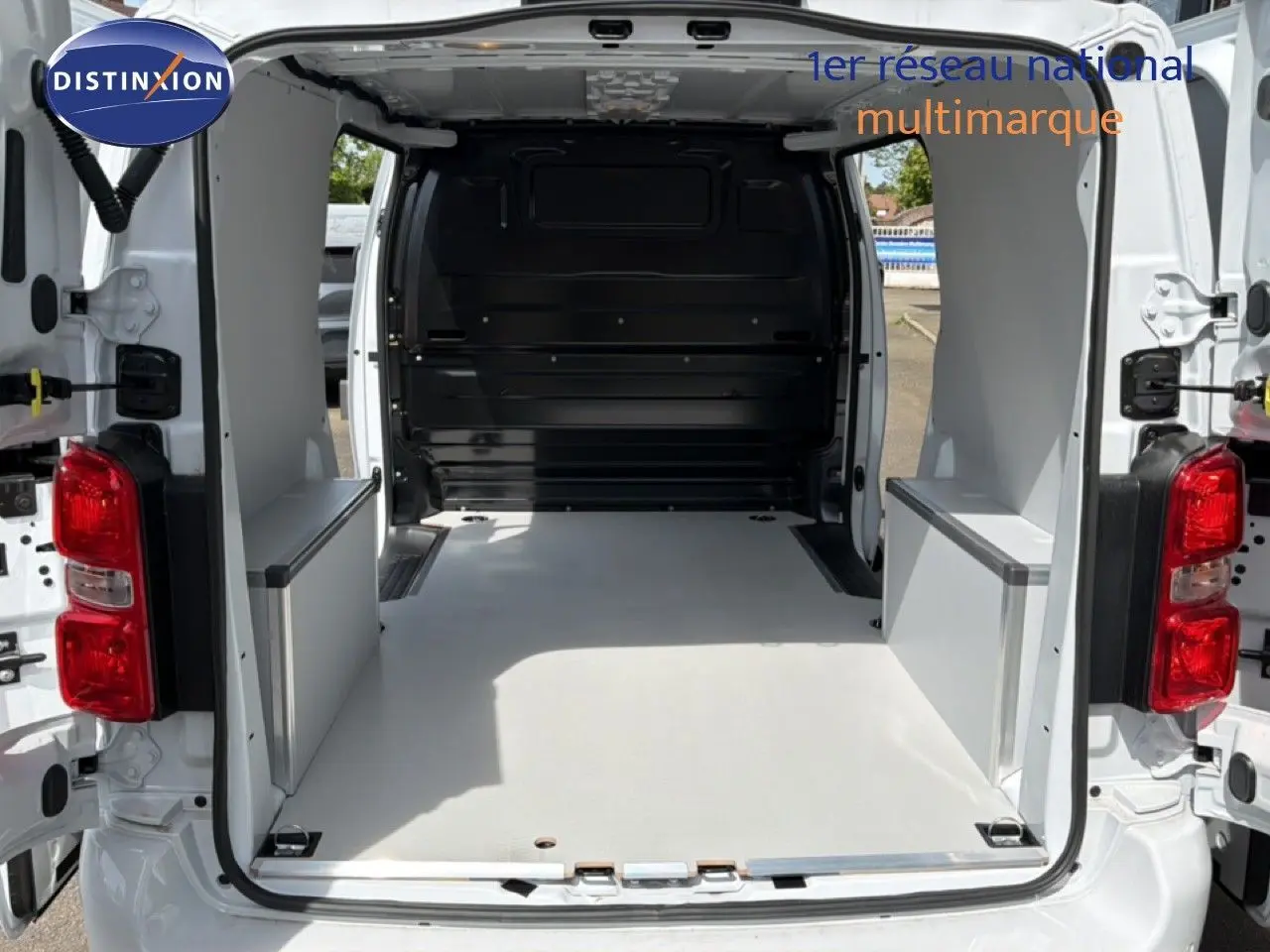 Vue arrière du Citroën Jumpy blanc Kaolin avec portes ouvertes montrant l’espace de chargement vide et aménagé.