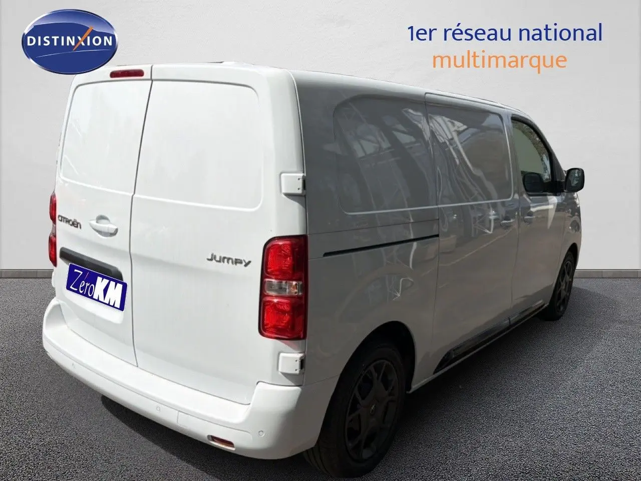 Vue 3/4 arrière droite d'un Citroën Jumpy blanc Kaolin, fourgon utilitaire avec vitres teintées et jantes noires.