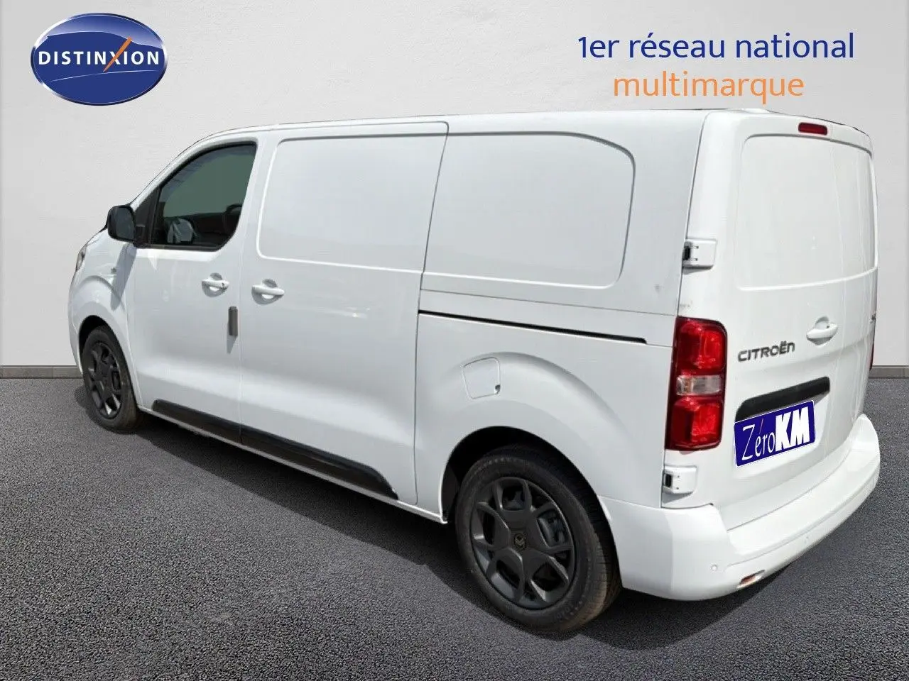 Vue 3/4 arrière droite d’un Citroën Jumpy blanc Kaolin, fourgon utilitaire avec jantes noires et vitres teintées.