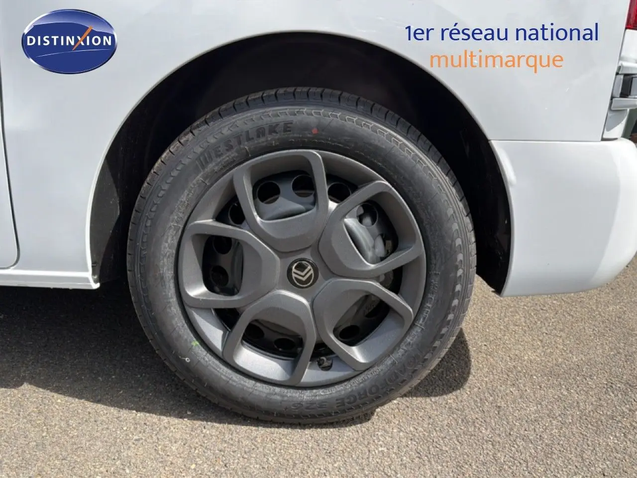 Gros plan sur la roue avant gauche du Citroën Jumpy blanc Kaolin, avec jante grise au design moderne.