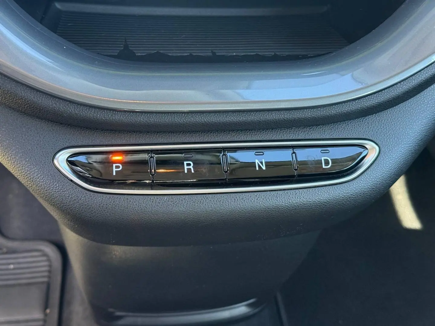 Gros plan sur la commande de boîte automatique avec bouton P allumé dans une Fiat 500 électrique jaune 2024.