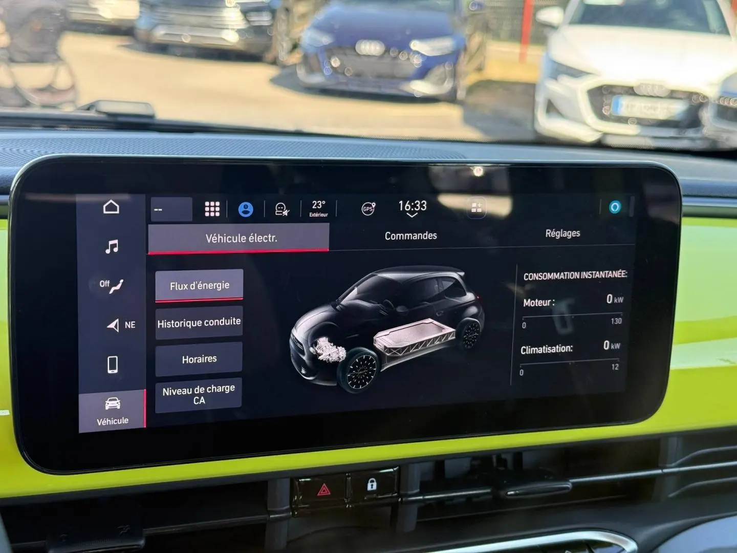 Écran tactile intérieur de la Fiat 500 e jaune montrant le flux d'énergie et la consommation instantanée.