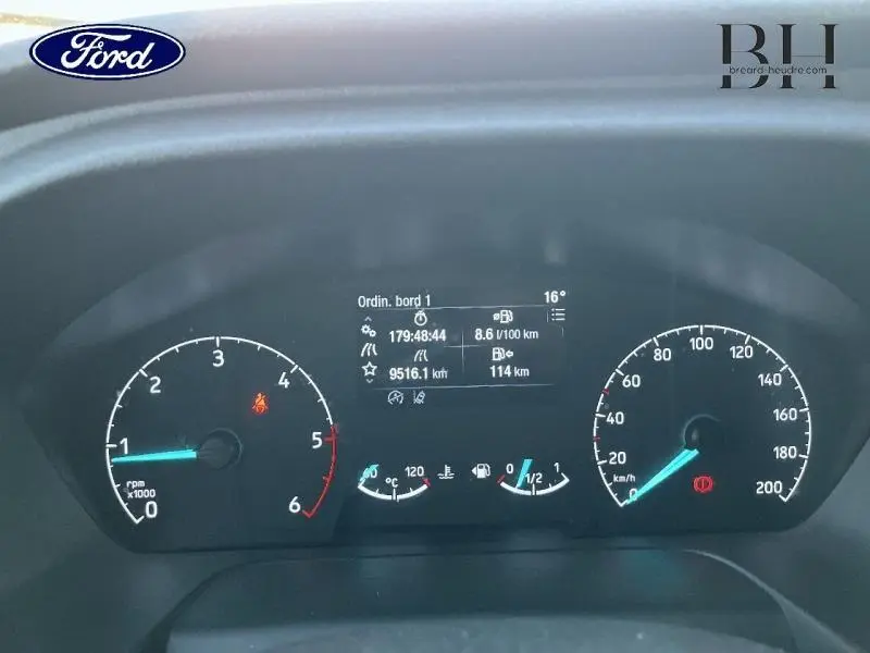 Tableau de bord du Ford Transit Custom gris Magnétic, affichage numérique et compteurs analogiques en vue frontale rapprochée.