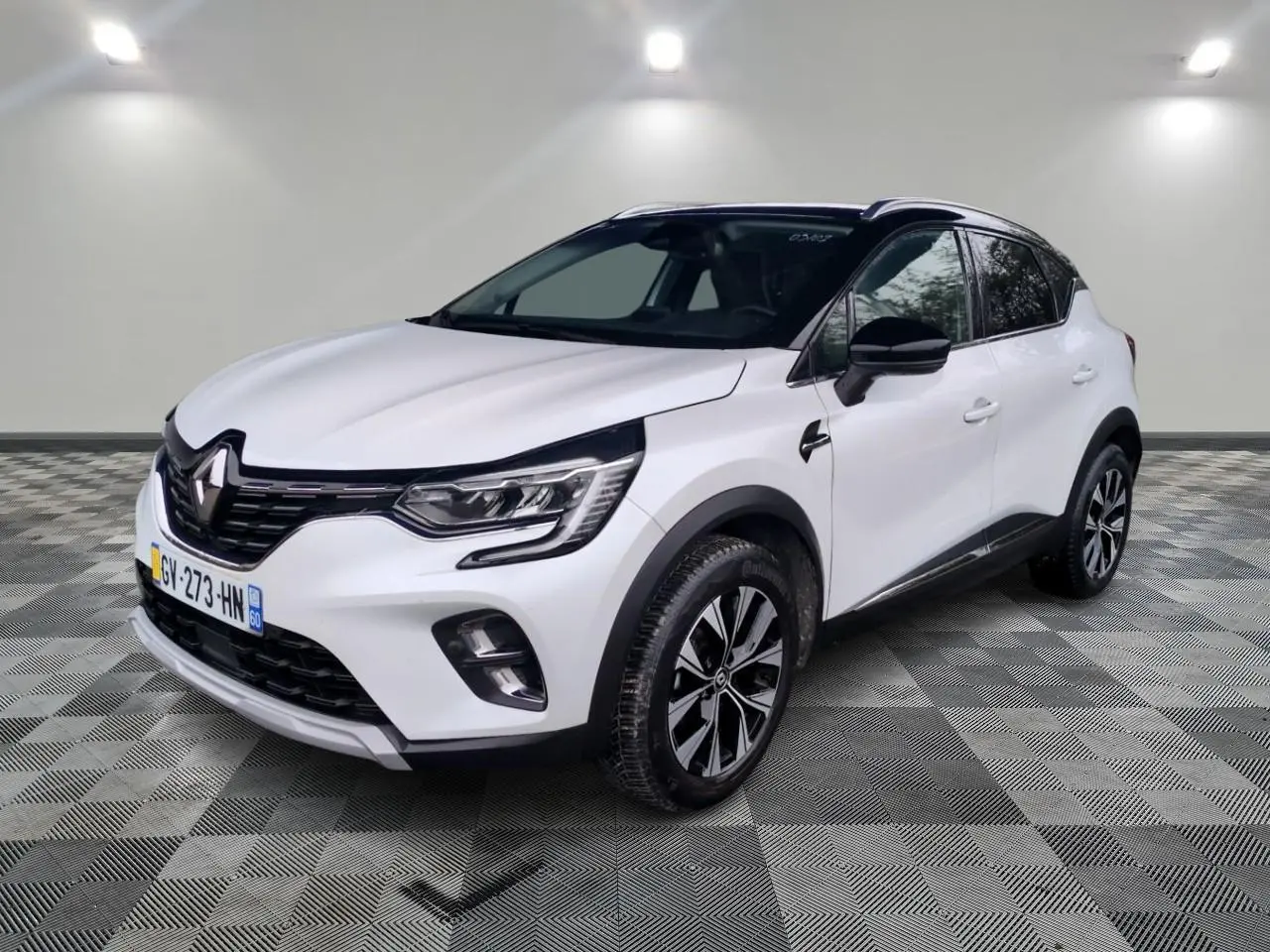 Renault Captur blanc vue 3/4 avant droit avec toit noir et jantes alliage bicolores sur fond neutre.