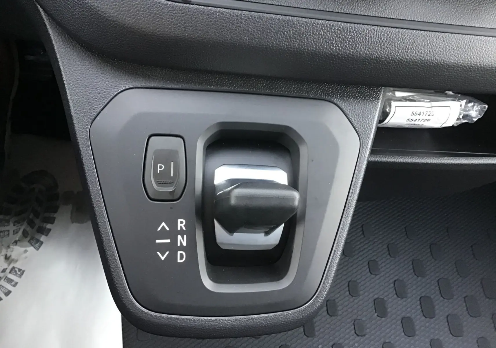 Gros plan sur le levier de vitesses automatique noir du Renault Trafic Fourgon blanc, avec bouton parking et indications R, N, D visibles.