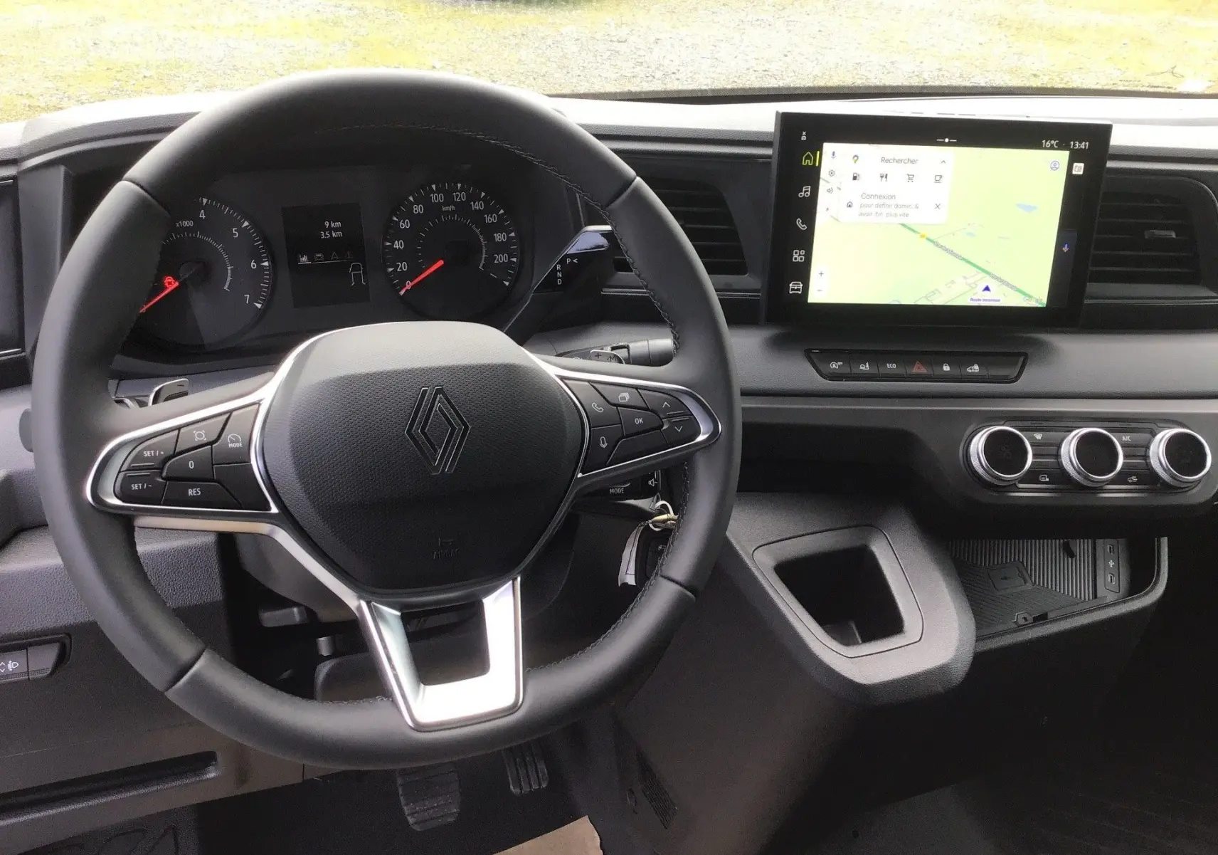 Vue intérieure centrée sur le volant et le tableau de bord du Renault Master blanc avec écran tactile et commandes au volant.