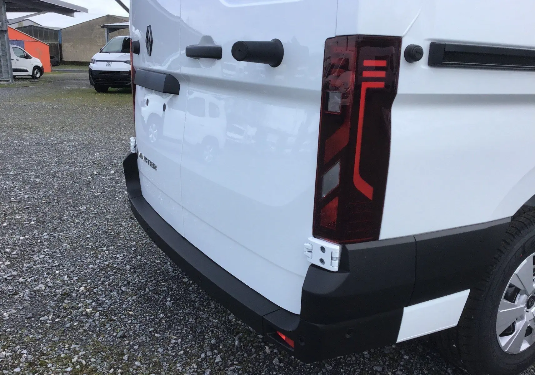 Vue arrière droite du Renault Master blanc, mettant en valeur le feu arrière LED et le pare-chocs noir robuste.