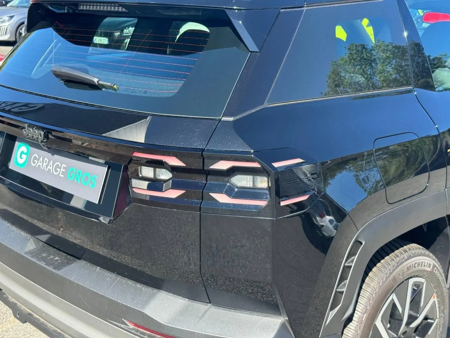 Vue 3/4 arrière droite du Jeep Compass 2026 couleur Vulcano avec feux arrière LED et jantes aluminium visibles.