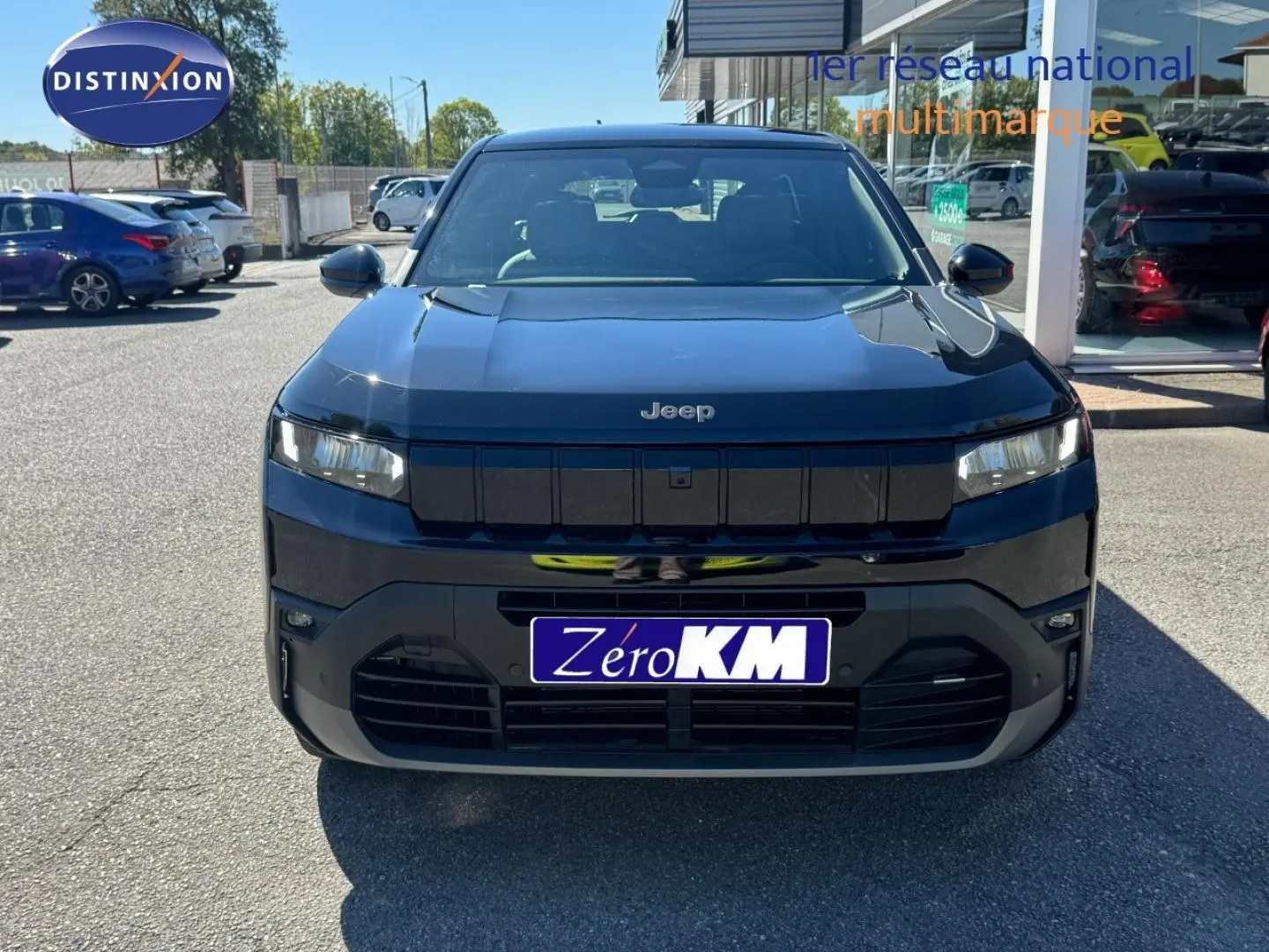 Vue avant d'un Jeep Compass 2026 couleur Vulcano avec calandre noire et phares LED fins, stationné en extérieur.