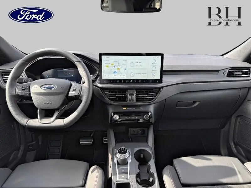 Vue intérieure frontale du tableau de bord du Ford Kuga 2025 gris avec écran tactile et volant multifonction.