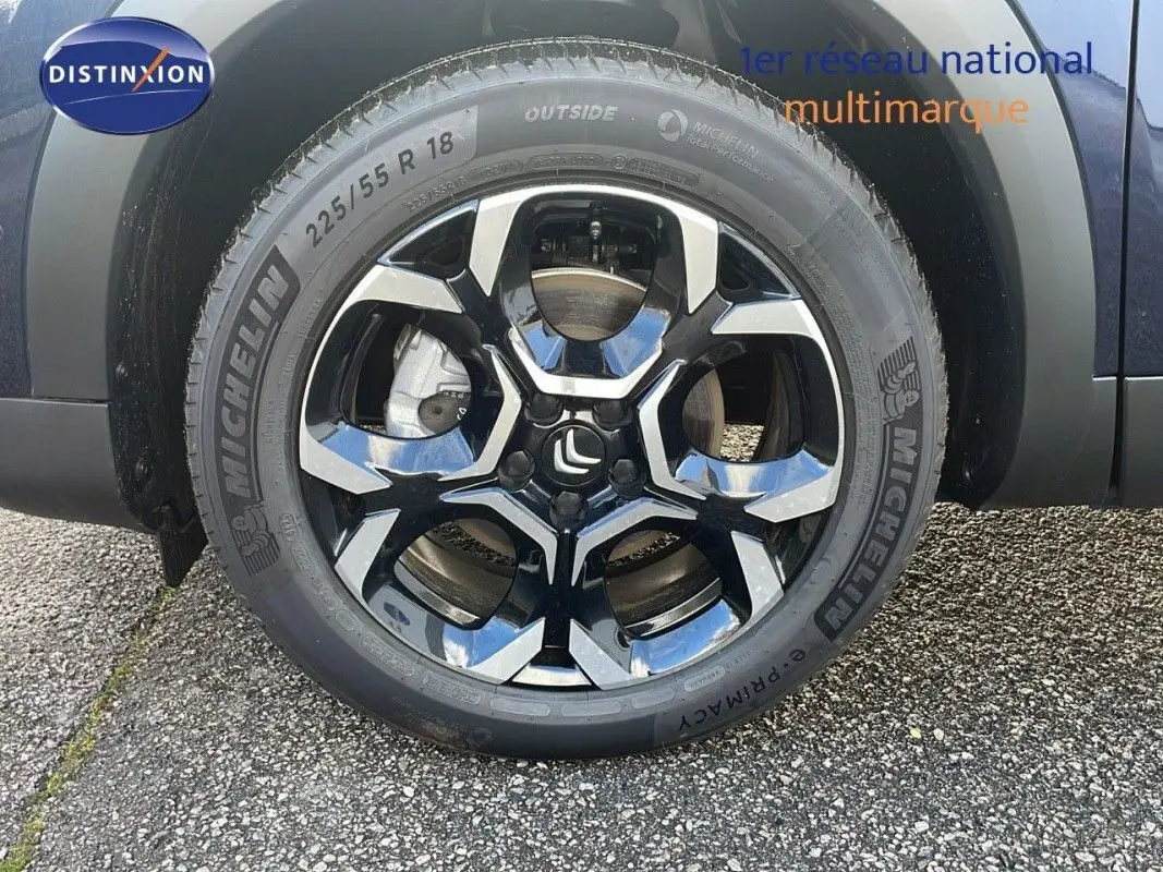 Gros plan sur la roue avant droite d'un Citroën C5 Aircross bleu Eclipse Métal avec jante alliage noire et argentée.