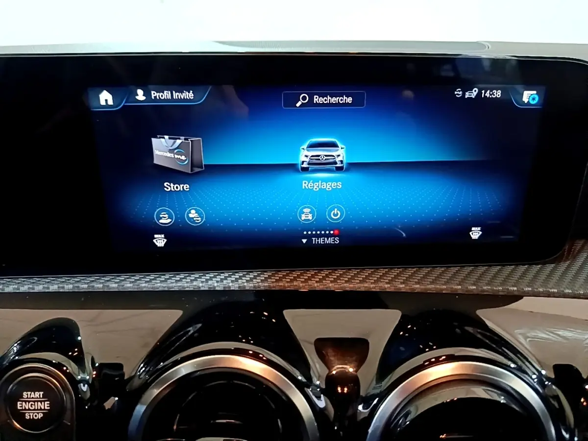 Vue rapprochée de l’écran tactile central et des aérateurs ronds noirs du tableau de bord gris foncé d’une Mercedes Classe A 180 d.