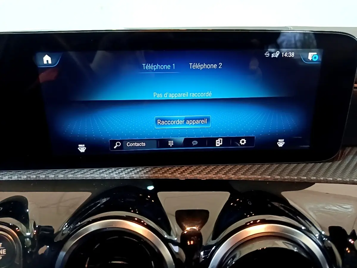 Vue rapprochée de l'écran tactile et des aérateurs ronds du tableau de bord de la Mercedes Classe A gris foncé.