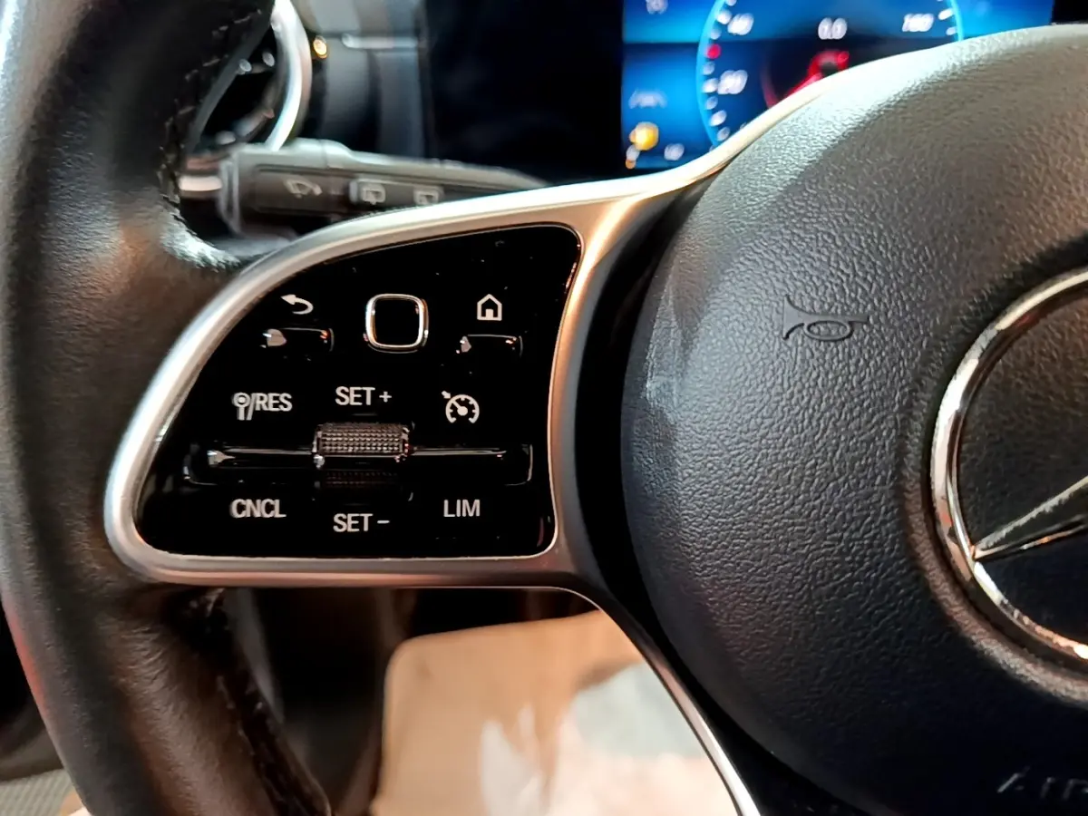 Gros plan sur le volant cuir noir de la Mercedes Classe A 180 d Business Line 2021 avec commandes multifonctions.