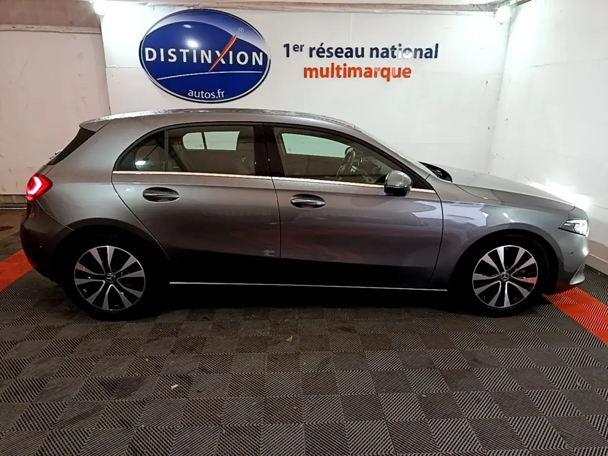 Vue de profil côté droit d'une Mercedes Classe A A 180 d Business Line gris foncé en intérieur showroom.