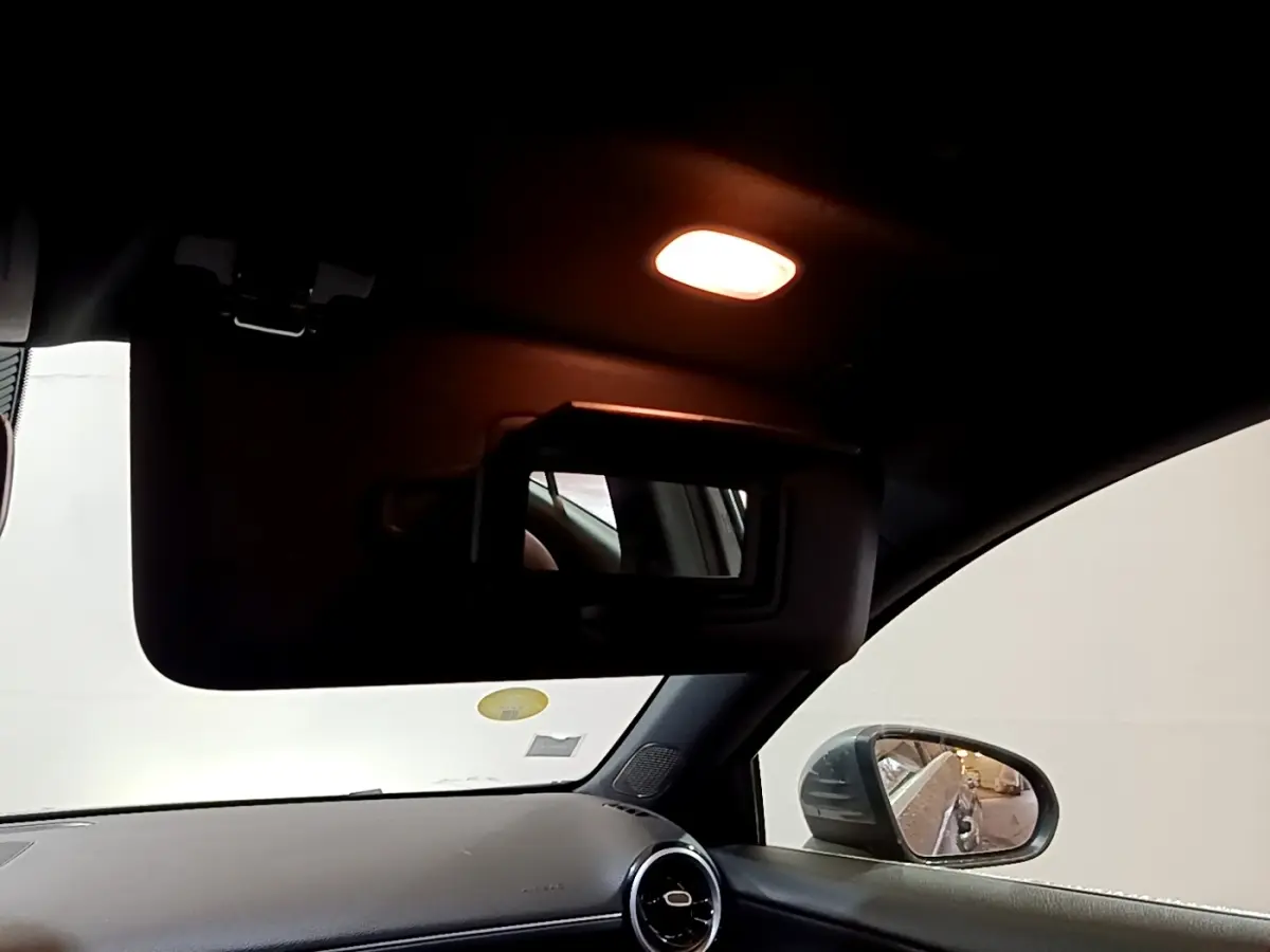 Intérieur de la Mercedes Classe A 180 d Business Line 2021, vue côté droit sur pare-soleil avec miroir et rétroviseur extérieur.