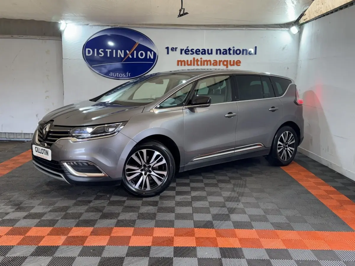 Renault Espace Initiale Paris gris foncé vu en 3/4 avant droit, avec jantes alliage et feux LED allumés.