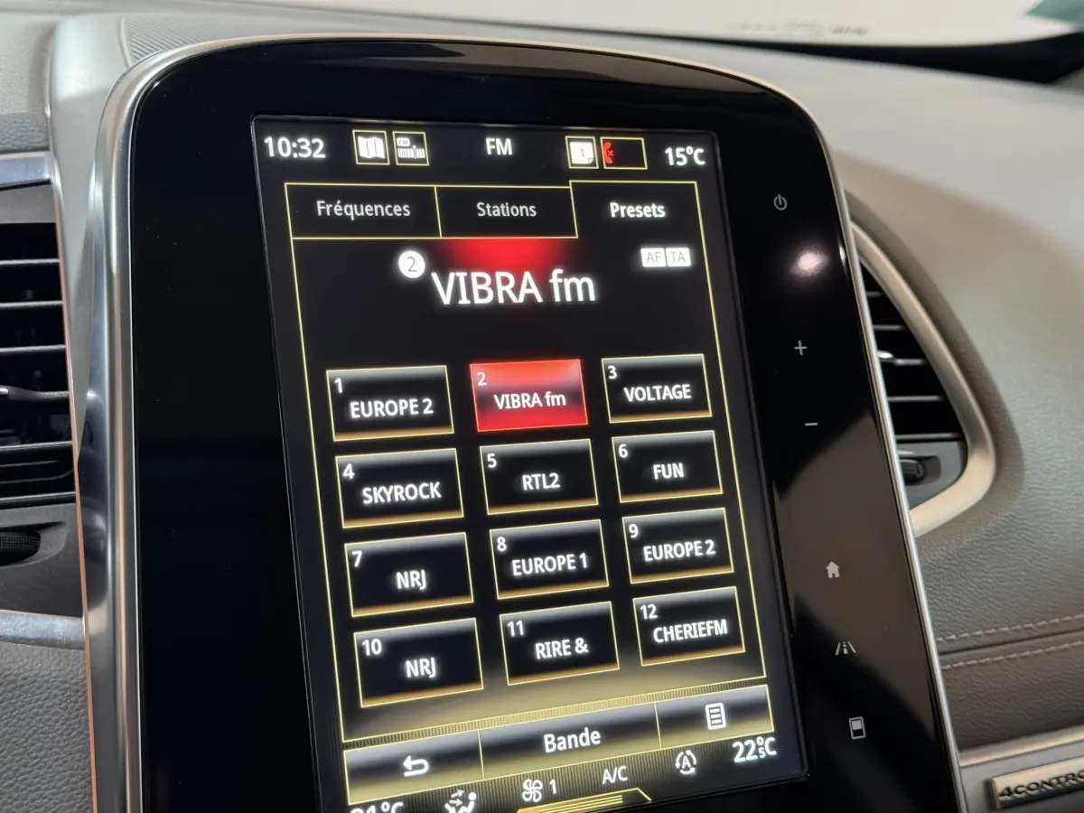 Gros plan sur l'écran tactile central du Renault Espace gris foncé, affichant les stations radio FM.