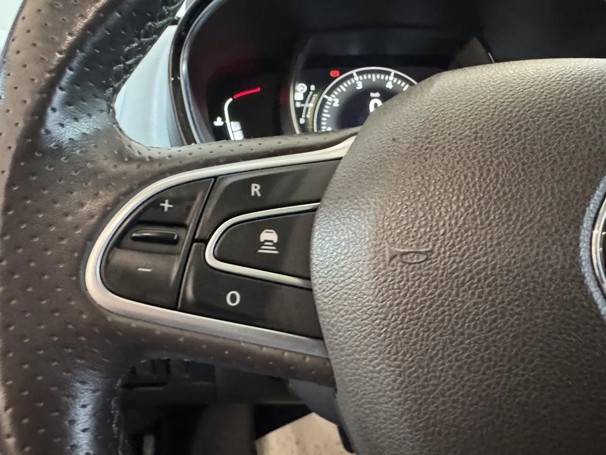 Gros plan sur le volant cuir gris foncé de la Renault Espace 2015, avec commandes de régulateur de vitesse visibles.