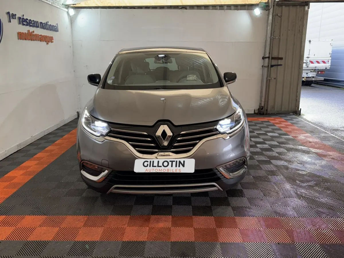 Vue avant d'un Renault Espace gris foncé 2015 avec phares LED allumés dans un garage éclairé.