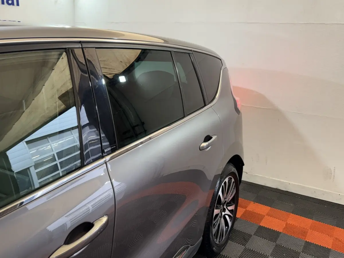 Vue côté gauche arrière d’un Renault Espace gris foncé avec vitres teintées et jantes alliage distinctives.