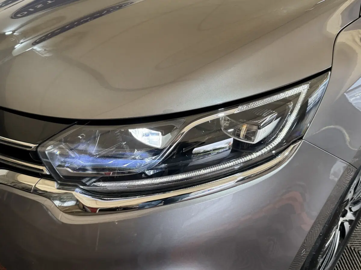 Gros plan sur le phare avant droit LED du Renault Espace gris foncé, soulignant les détails chromés autour.