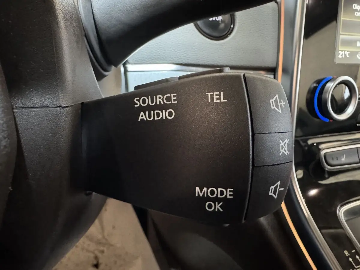 Gros plan sur la commande audio au volant d’un Renault Espace gris foncé, avec boutons source, téléphone et volume.