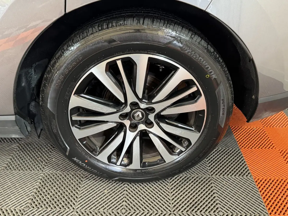 Gros plan sur la roue avant droite avec jante alliage bicolore du Renault Espace gris foncé 2015.