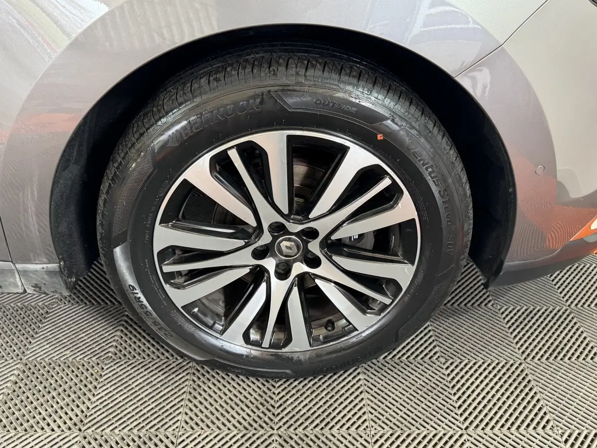 Gros plan sur la roue avant droite du Renault Espace gris foncé, mettant en valeur la jante alliage au design moderne.