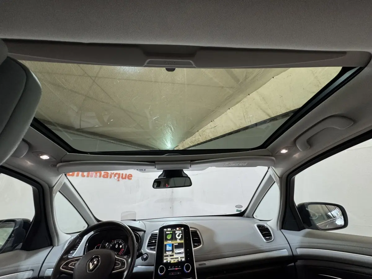 Vue intérieure avant du Renault Espace gris foncé 2015, avec grand toit panoramique et écran tactile central vertical.