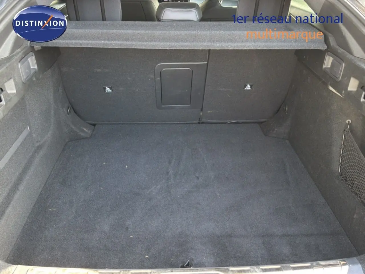 Coffre spacieux de Peugeot 408 gris selenium metal vu de l'intérieur avec banquette arrière en arrière-plan.