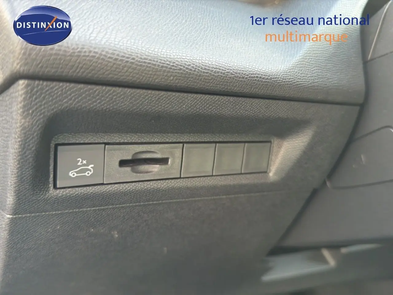 Vue rapprochée sur le tableau de bord noir texturé avec bouton d'ouverture du coffre de la Peugeot 408 gris selenium metal.