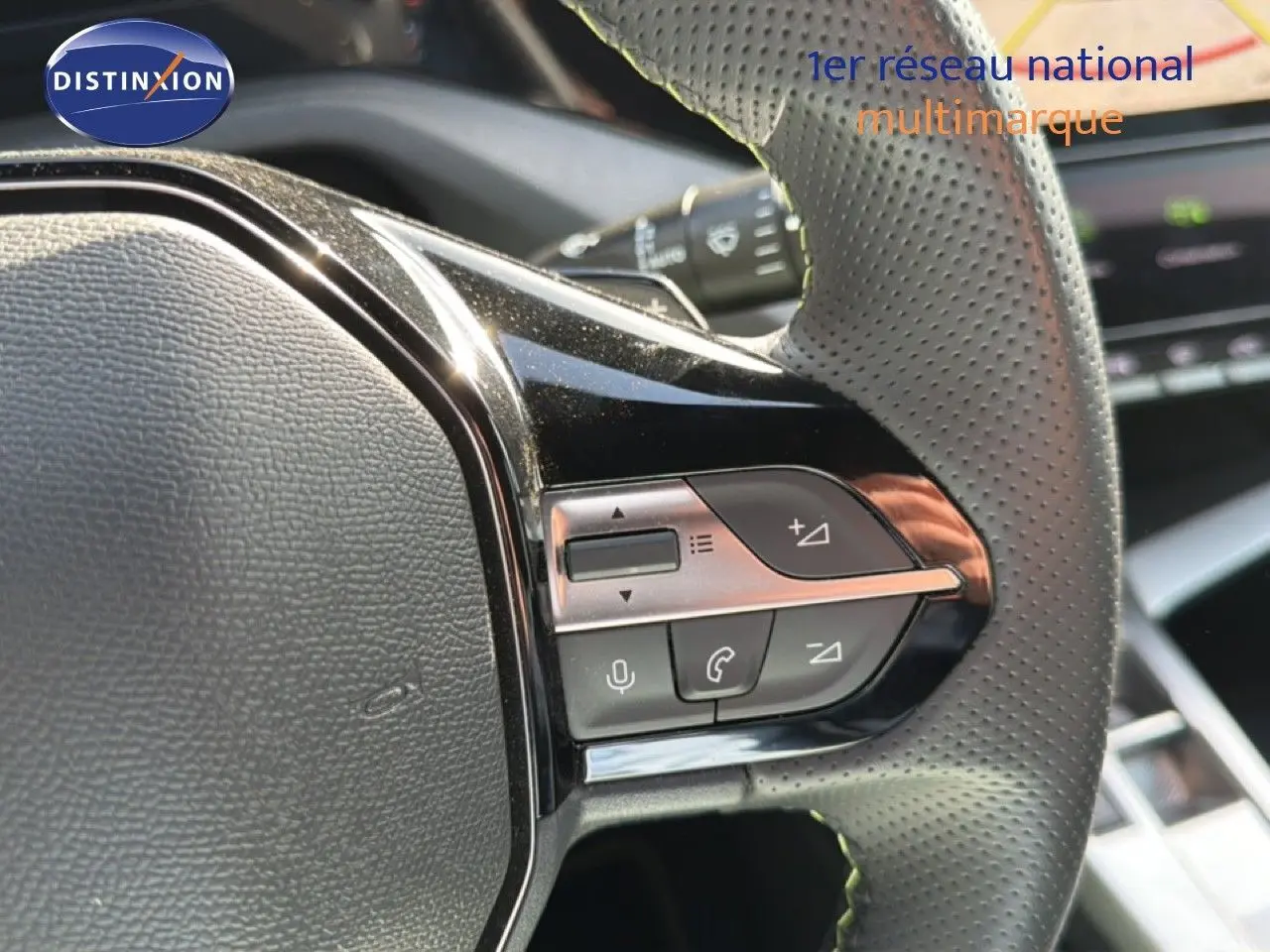 Gros plan sur les commandes multifonctions du volant en cuir perforé d’une Peugeot 408 gris selenium metal 2025.