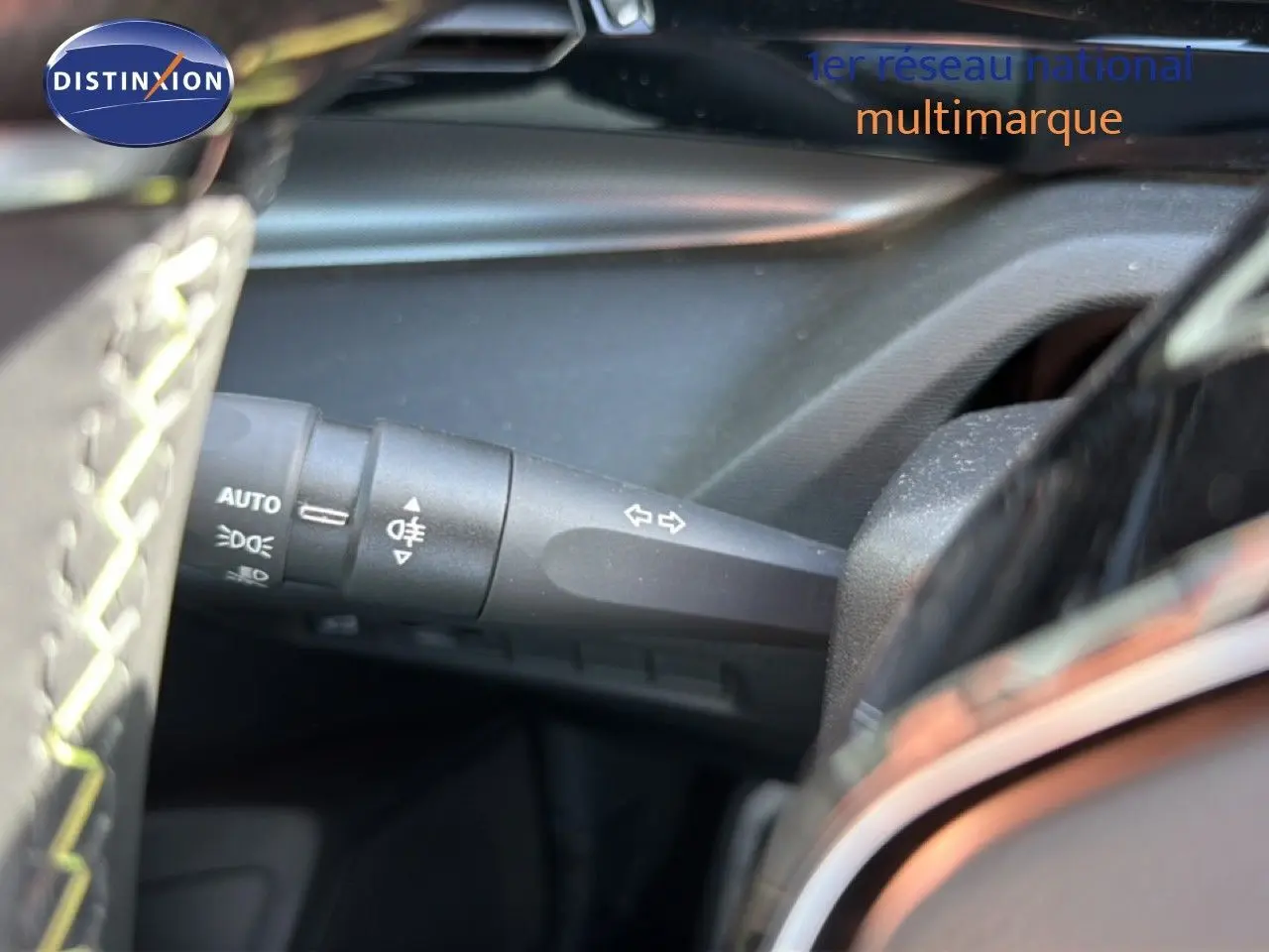Gros plan sur la commande des clignotants côté gauche dans l’habitacle noir d’une Peugeot 408 gris selenium.
