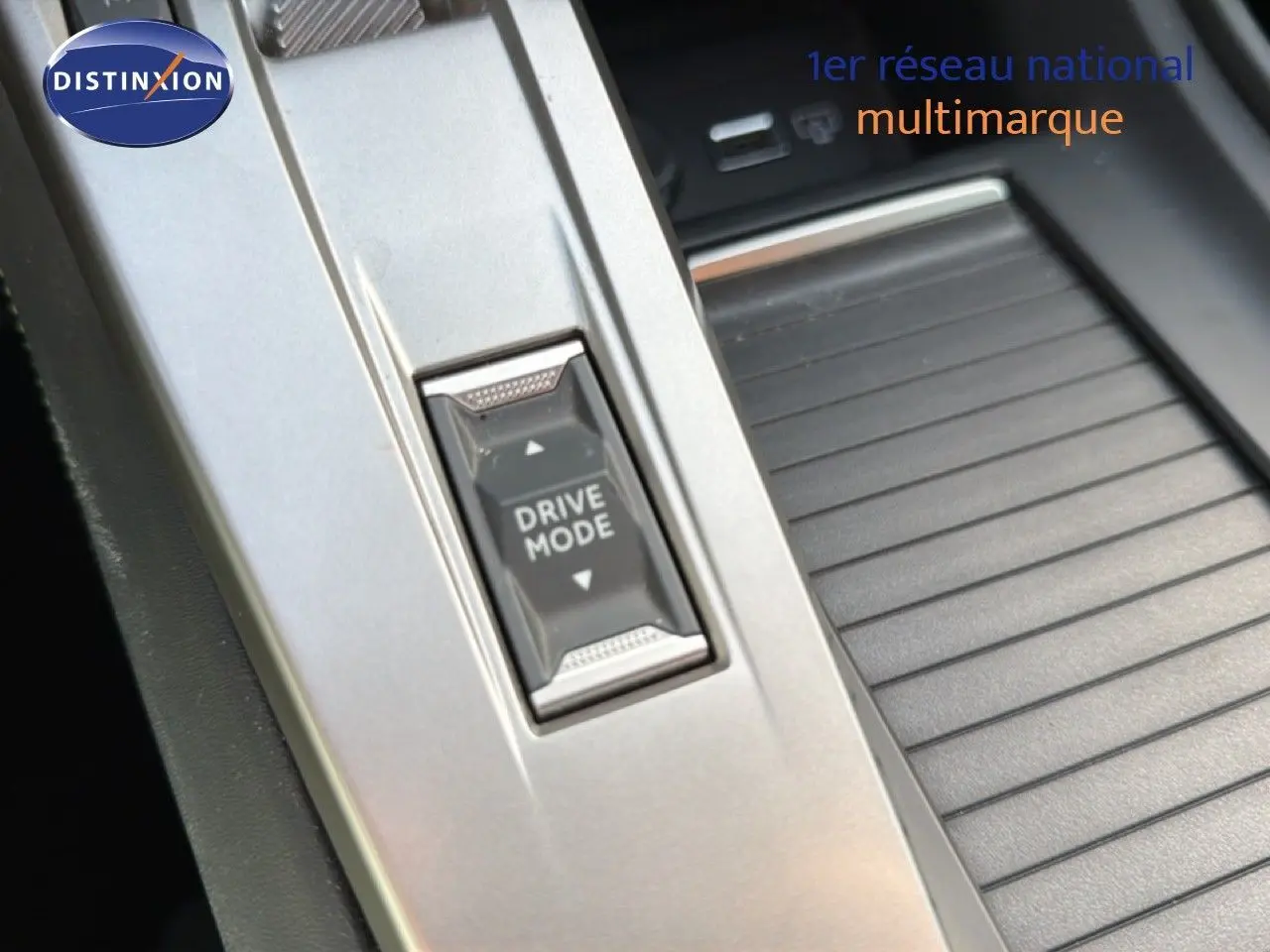 Gros plan sur le bouton Drive Mode dans la console centrale d’une Peugeot 408 gris selenium metal.