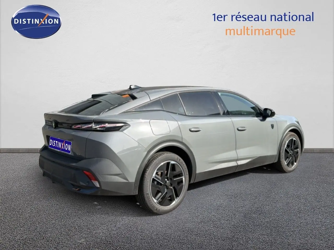 Vue 3/4 arrière droite d'une Peugeot 408 gris selenium métal avec jantes noires et toit panoramique.