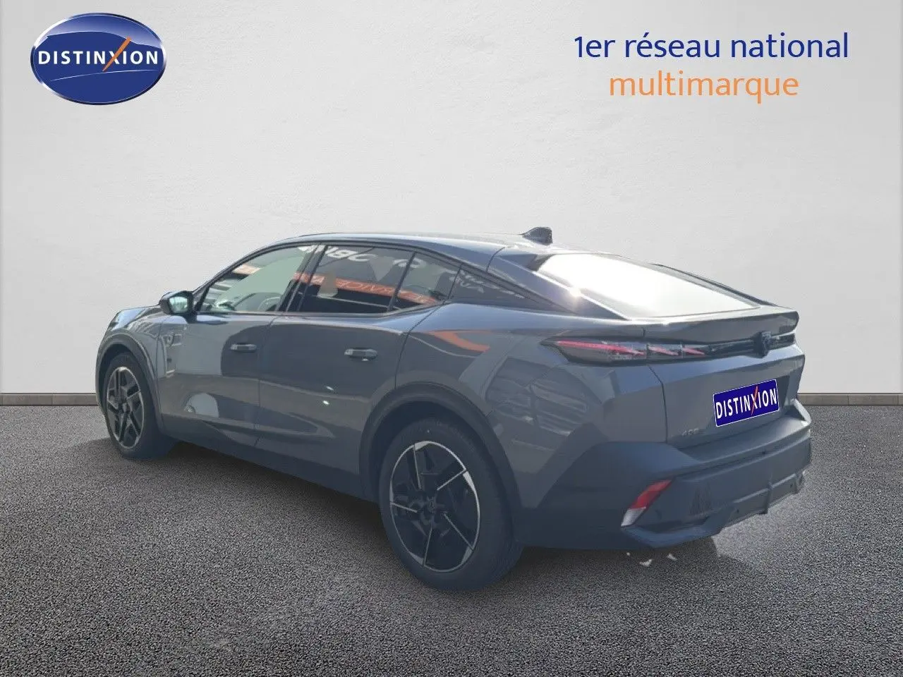 Peugeot 408 gris selenium métal vue 3/4 arrière droit, soulignant ses lignes fluides et ses jantes noires distinctives.