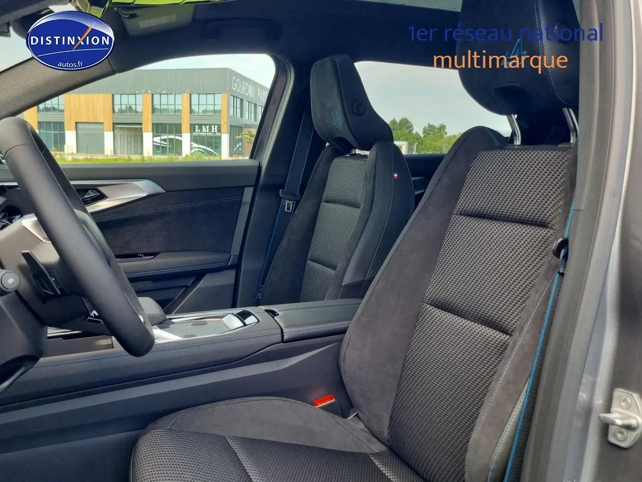 Vue intérieure côté conducteur du Renault Espace VI gris schiste, sièges en tissu carbone et alcantara avec surpiqûres bleues esprit Alpine.