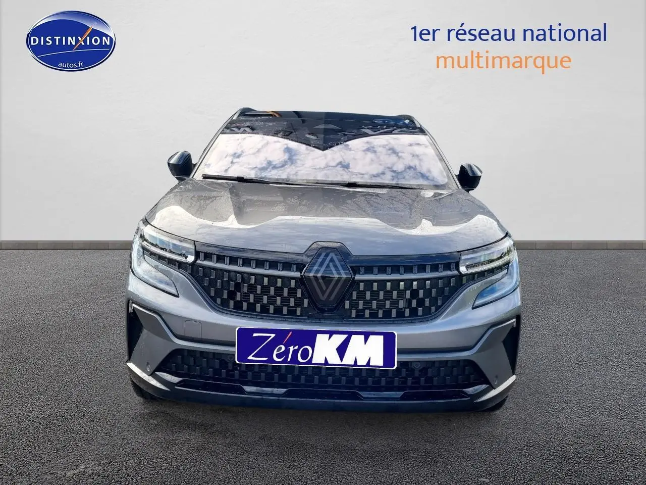 Vue frontale du Renault Espace VI gris schiste avec calandre damier et feux LED adaptatifs visibles.